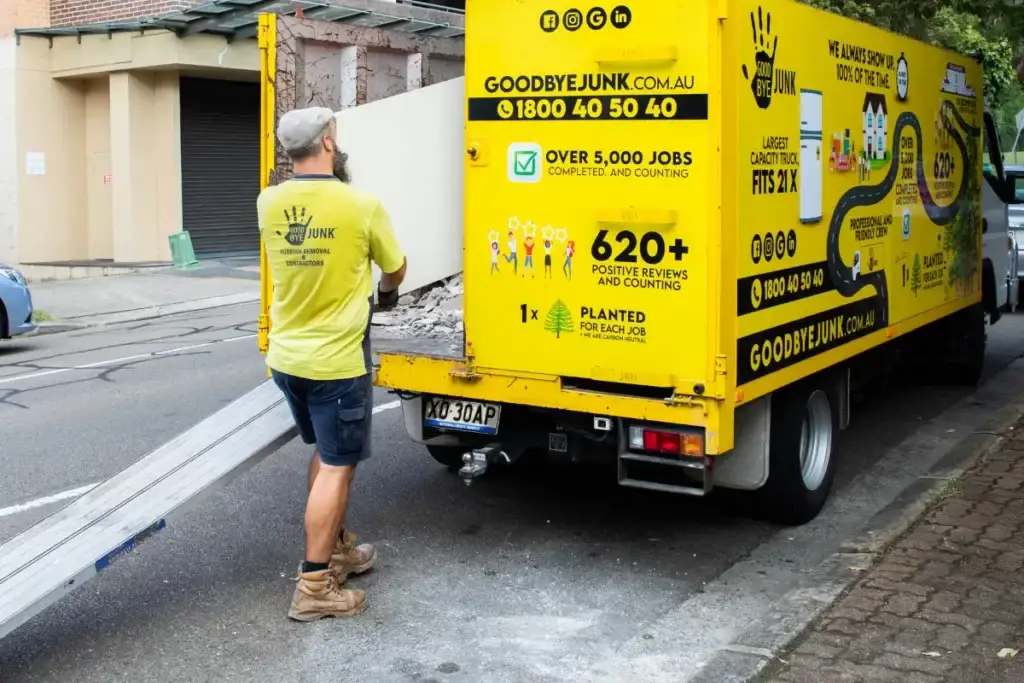 A goodbye junk worker collecting rubbish to a yellow truck