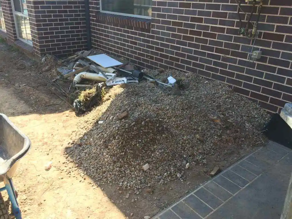 A pile of dirt next to a brick building