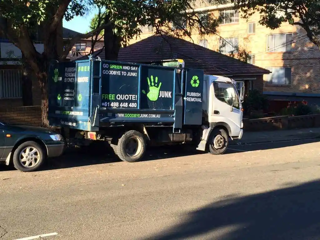 Goodbye Junk Rubbish Removal Truck parked on a street under a tree
