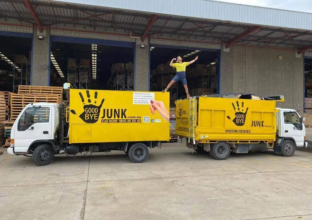 Goodbye junk worker standing on top between two trucks