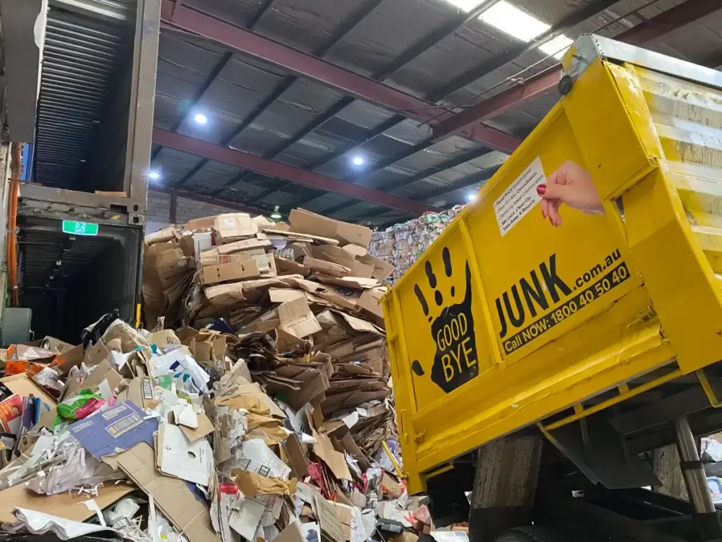 Goodbye junk yellow truck in a warehouse full of cardboard rubbish