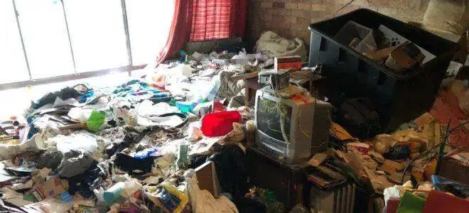 a messy room with a television and a lot of trash