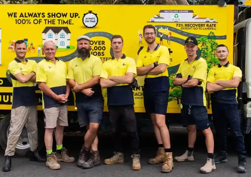 Goodbye junk workers standing in front of a yellow truck